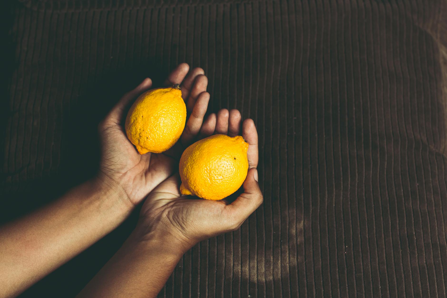 Fresh bright yellow lemons on a pastel green background, symbolizing vitality and pleasure