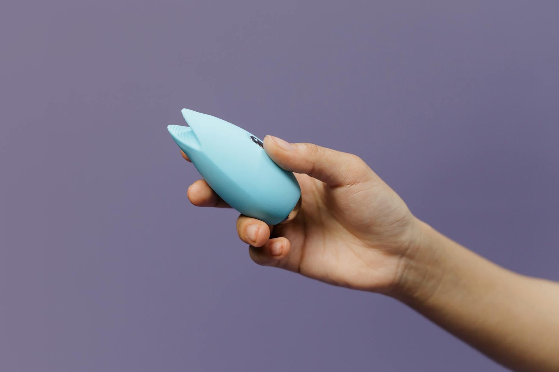 A blue silicone lemon vibrator held in hand, symbolizing self-care and reclaiming pleasure after illness