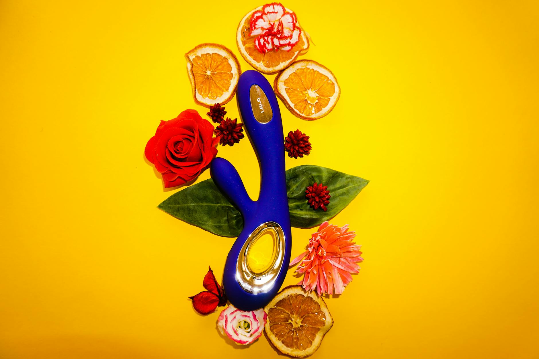 Yellow silicone vibrator surrounded by fresh lemons on a bright yellow background, representing fresh approaches to pleasure and anxiety relief